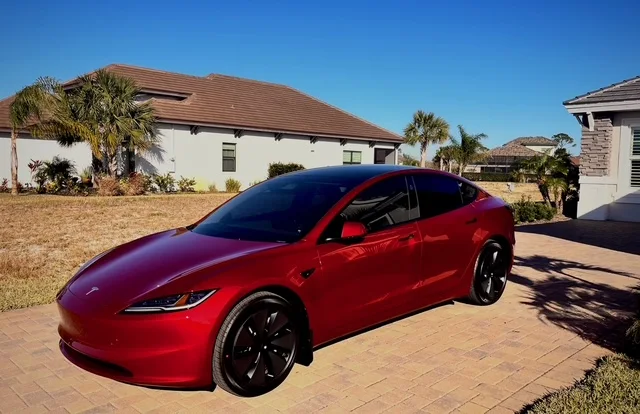 Red Tesla Model 3 — ceramic tint on a sunny Palm Coast driveway