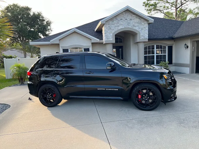 Black Jeep SRT at a beautiful Palm Coast home — full side profile