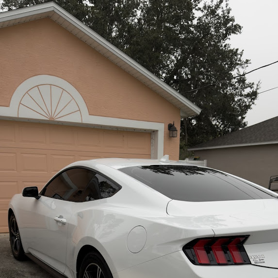 White Ford Mustang with ceramic-tinted rear window — Palm Coast customer driveway